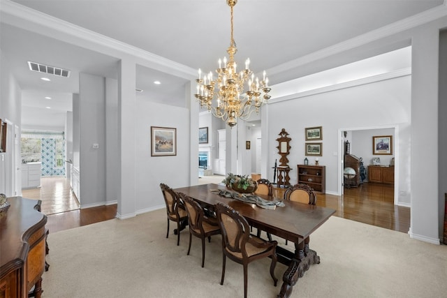 carpeted dining space featuring baseboards, visible vents, and crown molding