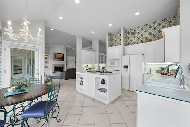 kitchen with white appliances, a fireplace, a sink, open shelves, and wallpapered walls