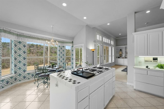 kitchen with tile countertops, light tile patterned floors, gas stovetop, and white cabinets