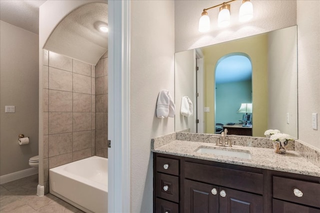 bathroom with baseboards, toilet, ensuite bathroom, tile patterned flooring, and vanity