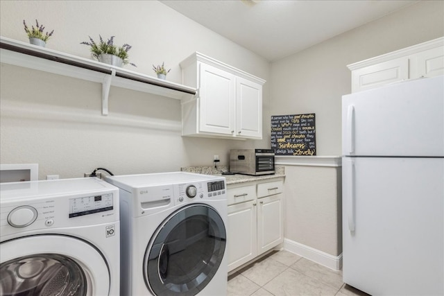 laundry room with cabinet space, a toaster, baseboards, washer and dryer, and light tile patterned flooring