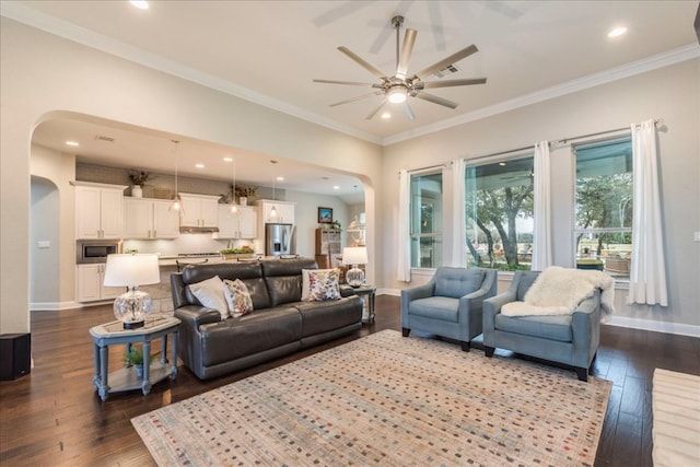 living room with arched walkways, dark wood finished floors, and baseboards