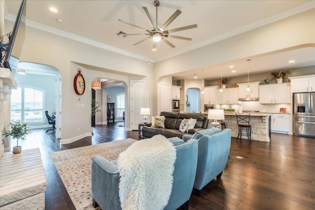 living room with arched walkways, baseboards, dark wood-style floors, and crown molding