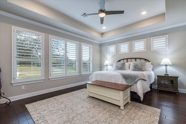 bedroom featuring dark wood finished floors, a raised ceiling, visible vents, and baseboards