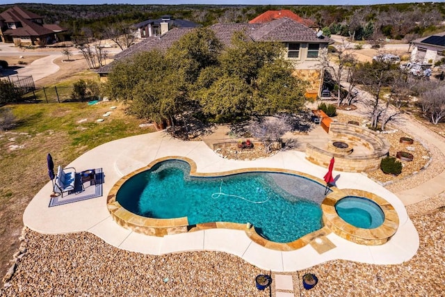 view of swimming pool featuring an in ground hot tub, a patio area, and fence