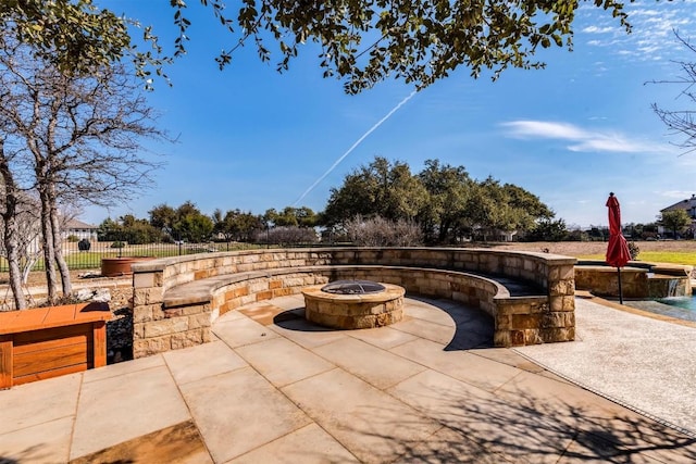 view of patio featuring fence and a fire pit