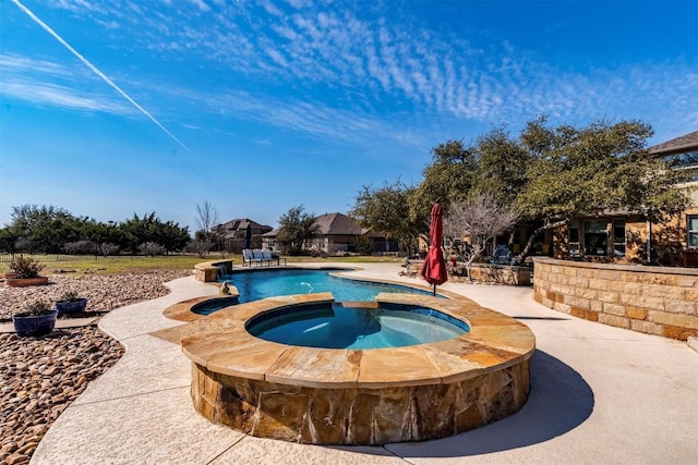 view of pool with a patio and an in ground hot tub