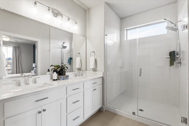 full bathroom with double vanity, tile patterned flooring, a sink, and a shower stall