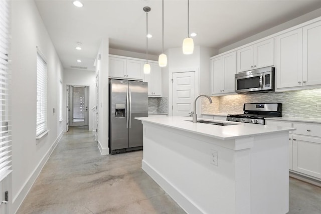 kitchen with stainless steel appliances, a sink, a center island with sink, and decorative backsplash