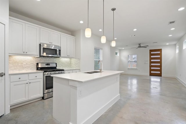 kitchen featuring baseboards, decorative backsplash, appliances with stainless steel finishes, concrete floors, and a sink