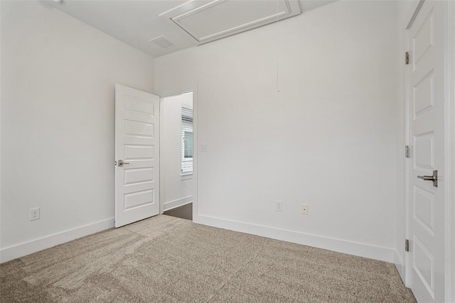 empty room with carpet floors, baseboards, and visible vents