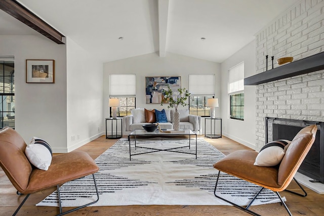 living room featuring vaulted ceiling with beams, a fireplace, light wood-style flooring, and baseboards