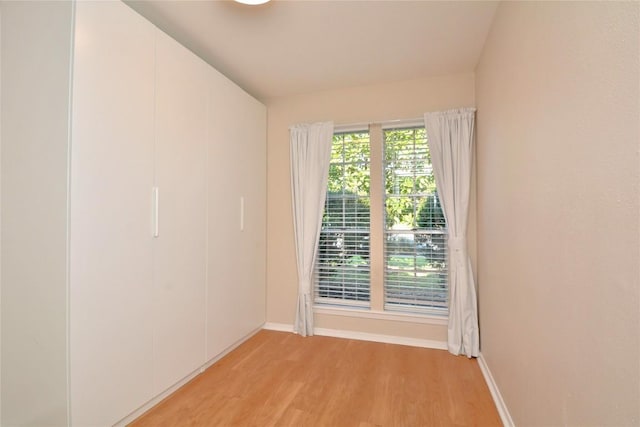 unfurnished room featuring light wood-type flooring and baseboards