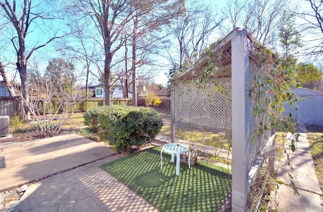 exterior space with fence private yard, a shed, a patio, and an outbuilding