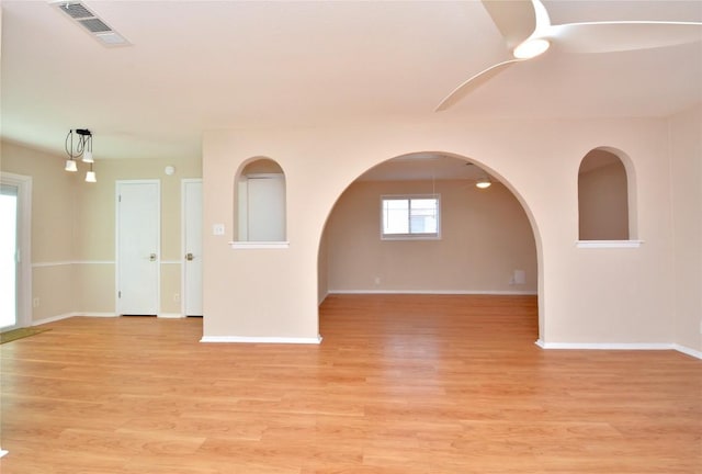 unfurnished room with light wood-style flooring, visible vents, and baseboards