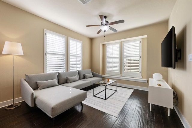 living area with ceiling fan, dark wood-type flooring, and baseboards