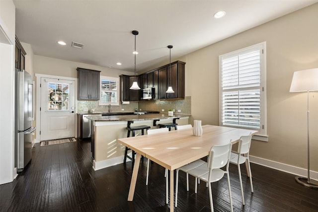 dining room with dark wood-style floors, recessed lighting, visible vents, and baseboards