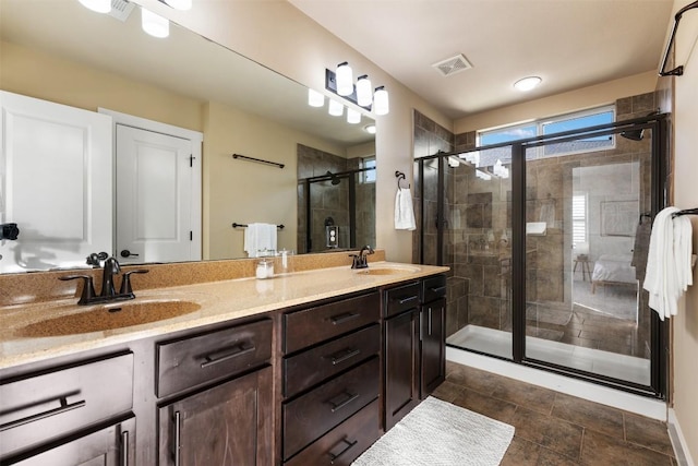 full bathroom featuring double vanity, a stall shower, a sink, and visible vents