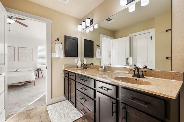 ensuite bathroom with double vanity, ceiling fan, visible vents, and a sink