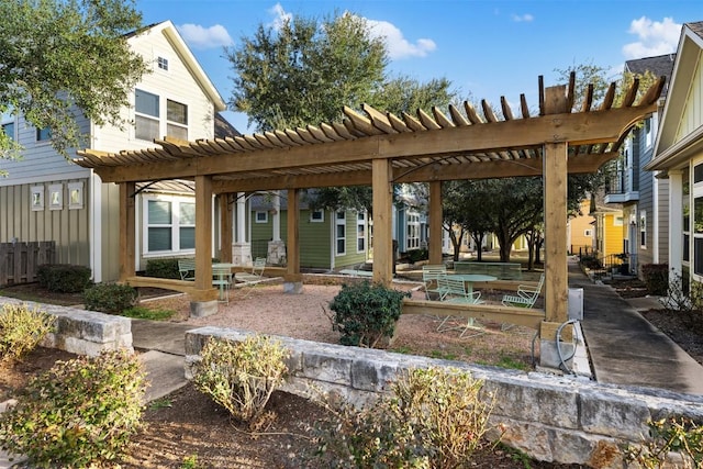 rear view of property with board and batten siding and a pergola