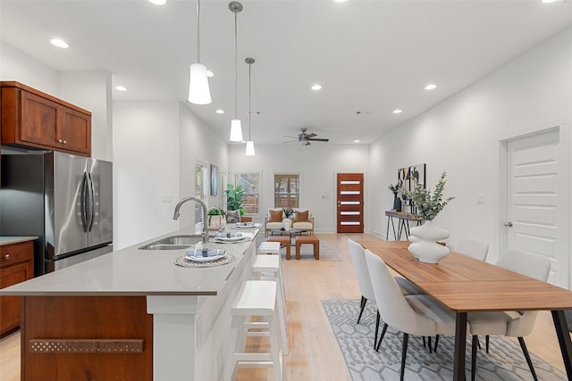 kitchen featuring recessed lighting, a sink, freestanding refrigerator, and light wood-style floors