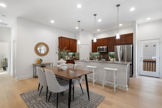 dining area with light wood-style flooring, visible vents, baseboards, and recessed lighting