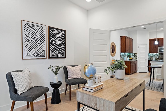 sitting room featuring baseboards, recessed lighting, and light wood-style floors