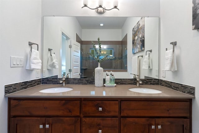 bathroom featuring backsplash, a sink, and a shower stall