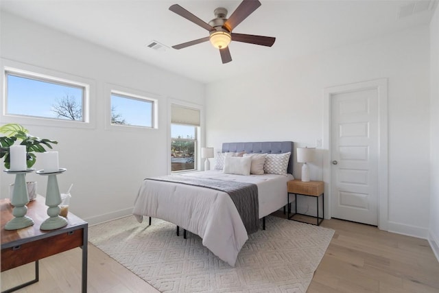 bedroom with visible vents, ceiling fan, light wood-style flooring, and baseboards