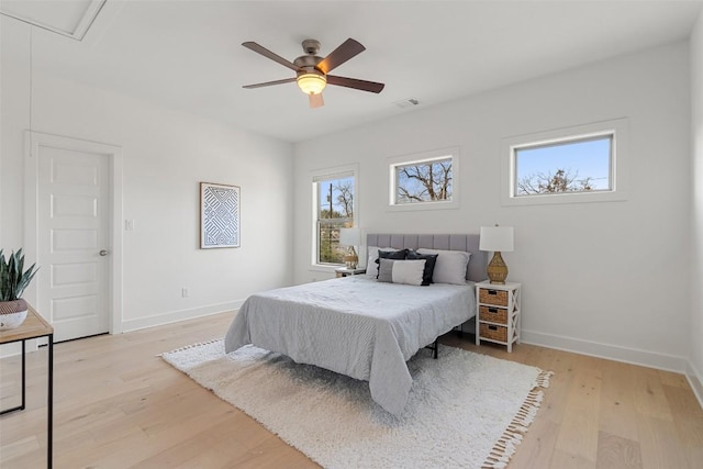 bedroom with attic access, baseboards, ceiling fan, and light wood finished floors