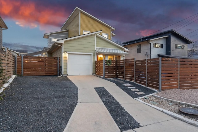 modern home with a fenced front yard, a gate, driveway, and a garage