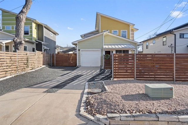 view of front of home featuring a garage, concrete driveway, and fence