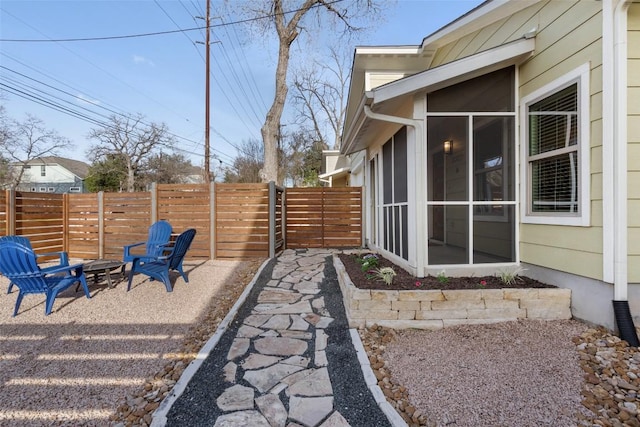 view of yard featuring a sunroom, an outdoor fire pit, and fence