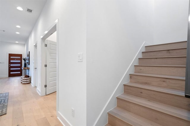 stairs featuring wood-type flooring, visible vents, baseboards, and recessed lighting