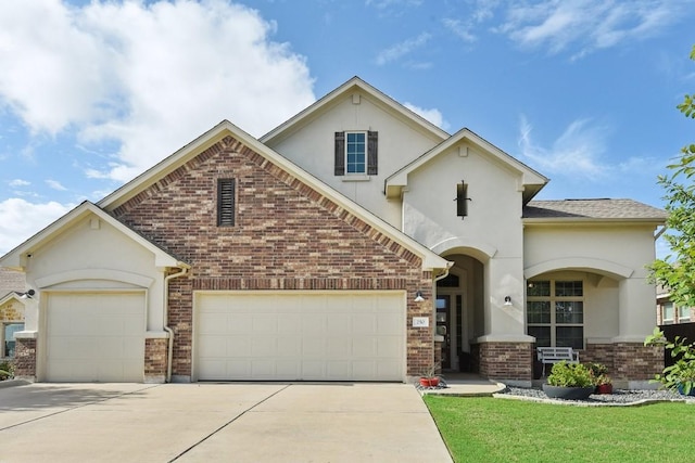 view of front facade with an attached garage, brick siding, concrete driveway, stucco siding, and a front lawn