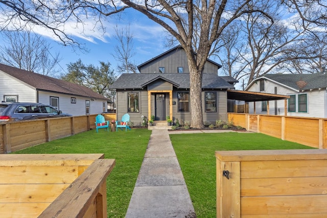 view of front of property with a front lawn, board and batten siding, and fence