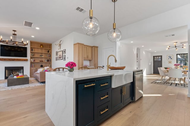 kitchen with open floor plan, visible vents, dishwasher, and a sink