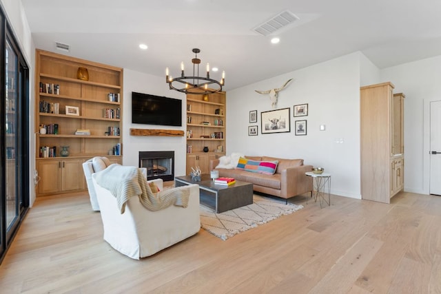 living area featuring a chandelier, recessed lighting, a fireplace, visible vents, and light wood-style floors