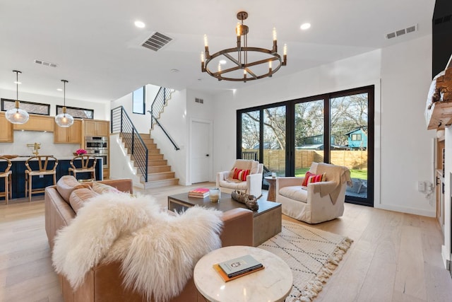 living area with light wood-type flooring, visible vents, recessed lighting, and stairs