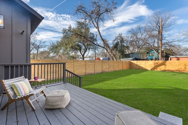 wooden deck with a yard and a fenced backyard