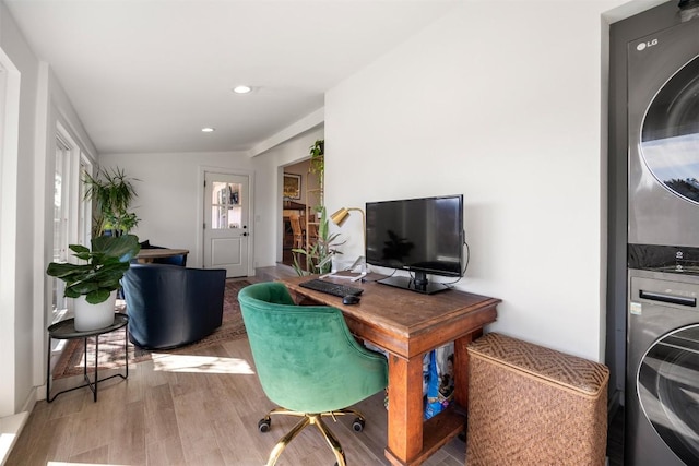 home office featuring stacked washer / dryer, light wood-type flooring, and recessed lighting