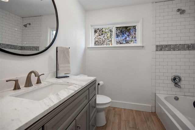 full bath featuring toilet, wood finished floors, vanity, baseboards, and shower / bathing tub combination