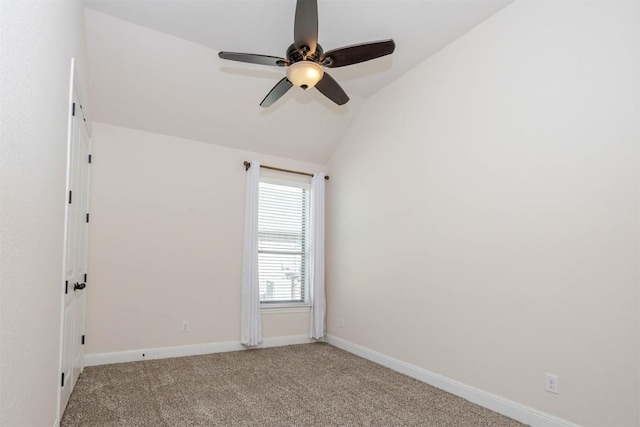 empty room featuring vaulted ceiling, baseboards, a ceiling fan, and light colored carpet