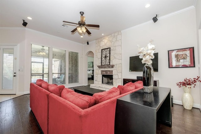 living room featuring dark wood-style floors, ornamental molding, a fireplace, and visible vents