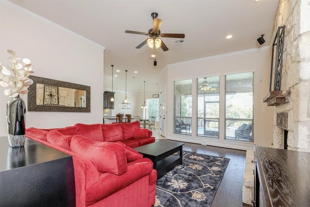 living area with ornamental molding, wood finished floors, and a healthy amount of sunlight