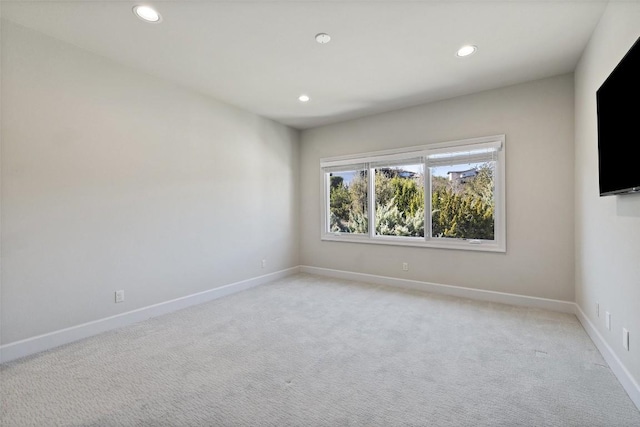 spare room with recessed lighting, light colored carpet, and baseboards