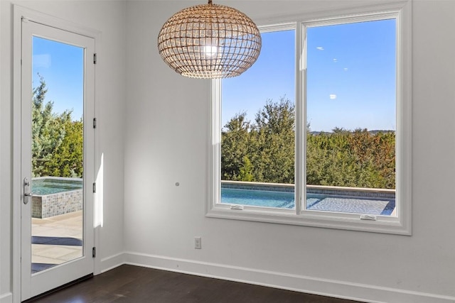 interior space featuring baseboards, dark wood finished floors, and a chandelier