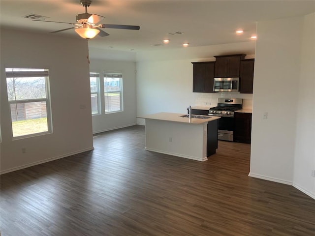 kitchen featuring a sink, visible vents, open floor plan, appliances with stainless steel finishes, and an island with sink