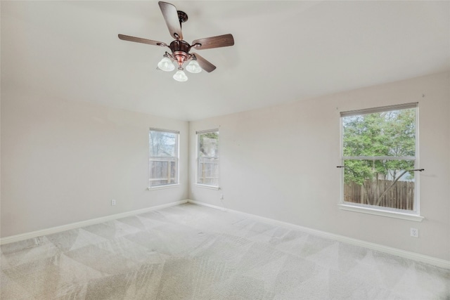 spare room with light carpet, baseboards, and a ceiling fan