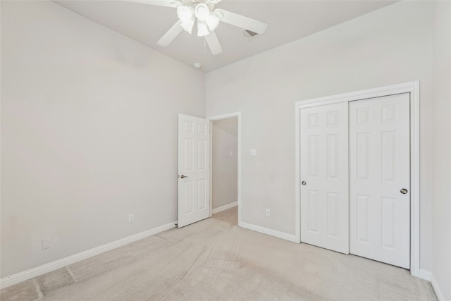 unfurnished bedroom featuring a ceiling fan, baseboards, a closet, and light colored carpet